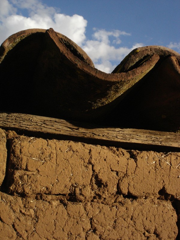 Toma cercana de elementos constructivos tradicionales; adobe, madera y teja.